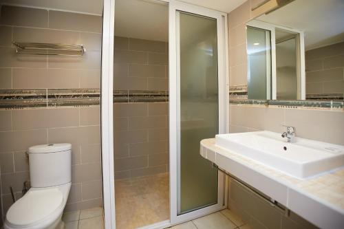 a bathroom with a sink and a toilet and a mirror at Anjary Hotel Antananarivo in Antananarivo