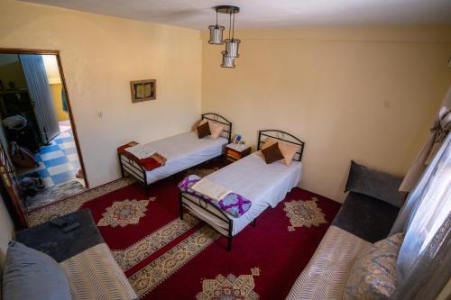 1 dormitorio con 2 camas y espejo en Takad Dream Rural, en El Borj