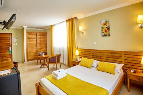 a hotel room with a large bed and a desk at Anjary Hotel Antananarivo in Antananarivo