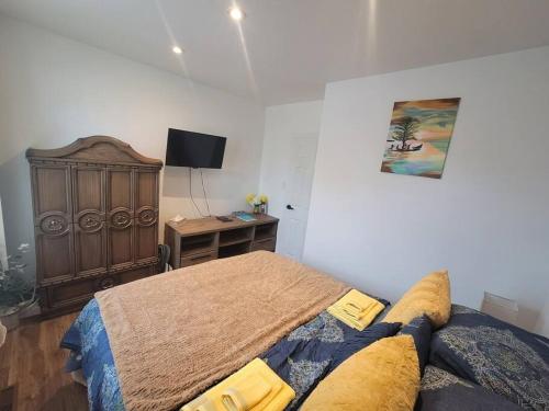 a bedroom with a bed and a desk with a television at Bright apartment close to hwy in Edmundston