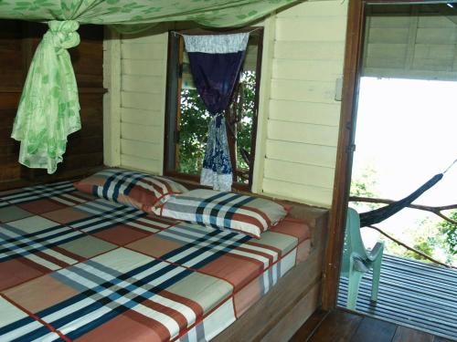 昌岛Littleduck bungalow Koh Chang Ranong的坐在房子门廊上的一张床