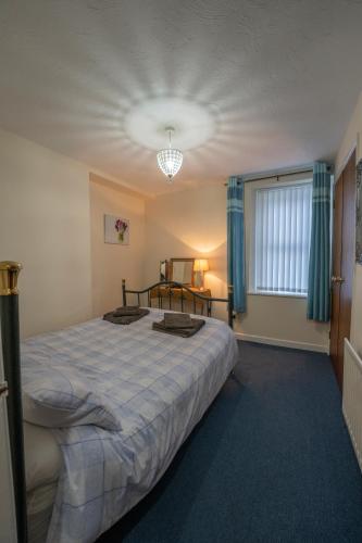 a bedroom with a bed and a window with blue curtains at Waterfall Cottage in Carnlough