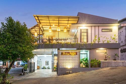 a house with a balcony with lights on it at Destiny House in Yogyakarta