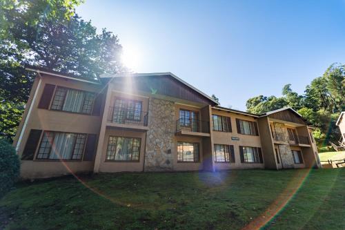 a large building with the sun shining on it at Gooderson Drakensberg Gardens Golf & Spa Resort in Drakensberg Garden