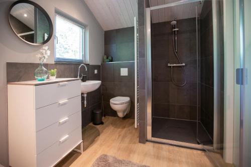 een badkamer met een douche, een wastafel en een toilet bij Vakantiepark Latour in Oirschot