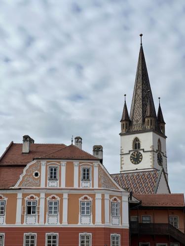 a building with a clock tower on top of it at Atmosfera Sibiu in Sibiu