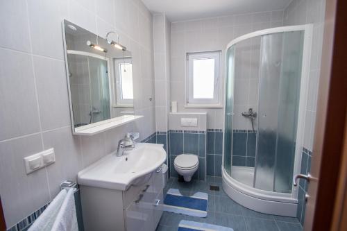 a bathroom with a sink and a toilet and a shower at Apartments Kelić in Trogir