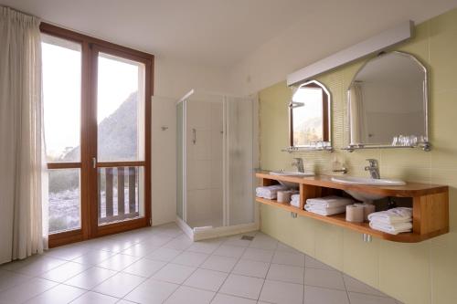 a bathroom with a shower and a sink and a mirror at Hotel Boka in Bovec