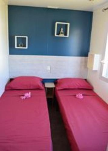 - 2 lits rouges dans une chambre avec un mur bleu dans l'établissement Mobil Home 4 personnes, à Puget-sur Argens