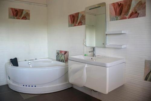 biała łazienka z umywalką i wanną w obiekcie STEPHEN HOTEL w mieście Toamasina