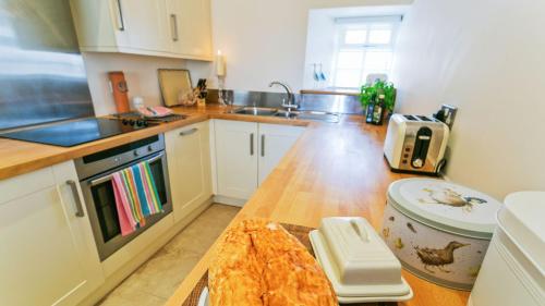 a kitchen with a counter top with a pizza on it at Buttercup in Llanrhyddlad