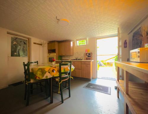une cuisine avec une table et des chaises dans une pièce dans l'établissement Chambre en rez de jardin, à Gland