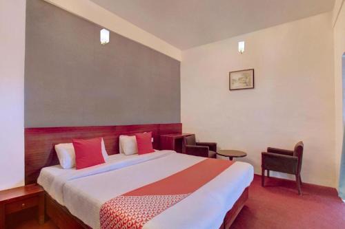 pokój hotelowy z dużym łóżkiem i krzesłami w obiekcie Flagship Ooty Residency w mieście Utakamand