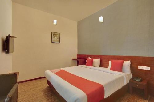 a hotel room with a large bed with red pillows at Flagship Ooty Residency in Ooty