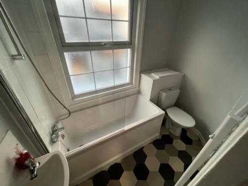 een badkamer met een wastafel, een toilet en een raam bij Cosy 2-bed Town House In Central Brighton Sleep 4 in Brighton & Hove