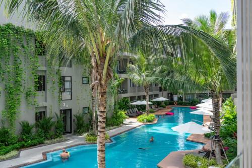 vista sulla piscina del resort con palme di Diamond Phuket Bang Tao a Bang Tao Beach
