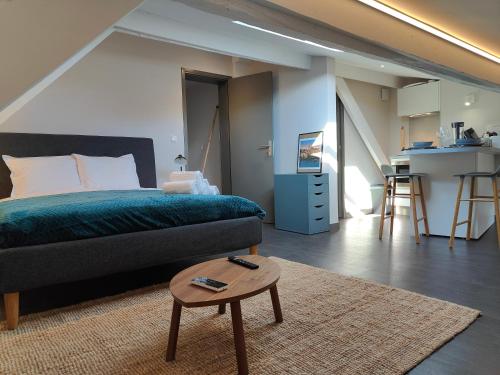 une chambre avec un lit et une table et une cuisine dans l'établissement L'Envolée - Fibre - Clim - Centre-ville, à Albi