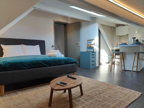 une chambre avec un lit et une table et une cuisine dans l'établissement L'Envolée - Fibre - Clim - Centre-ville, à Albi
