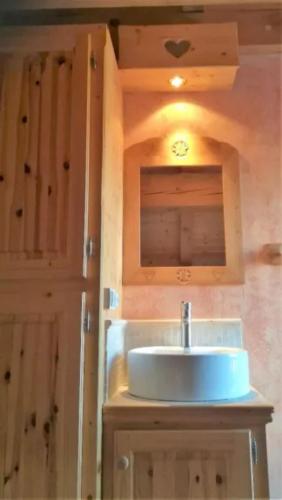 une salle de bain avec un lavabo et un miroir dans l'établissement Le Tyrol, à La Plagne Tarentaise