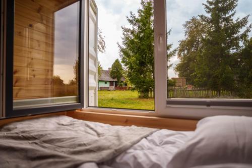 a bed in a room with two large windows at Arche Siedlisko Augustynka 39 in Augustynka