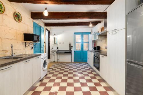 a kitchen with blue doors and a checkered floor at Traditional Maltese Townhouse - Close to Sea in Senglea