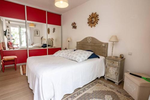 - une chambre avec un lit blanc et des murs rouges dans l'établissement Le maréchal, à Sète