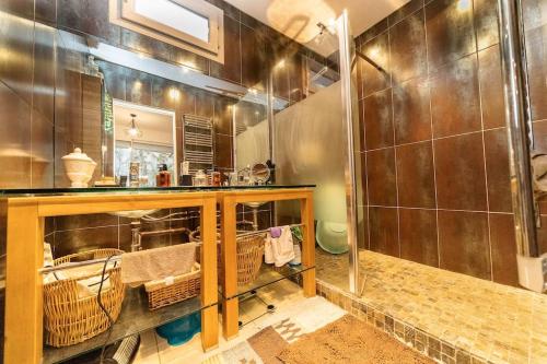 une salle de bain avec un lavabo et une douche avec paniers dans l'établissement Le maréchal, à Sète