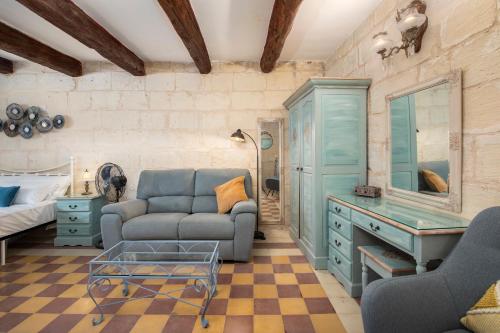 a living room with a couch and a table at Traditional Maltese Townhouse - Close to Sea in Senglea