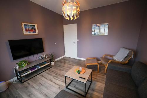 a living room with a couch and a tv at Olga Apartments in Grundarfjordur