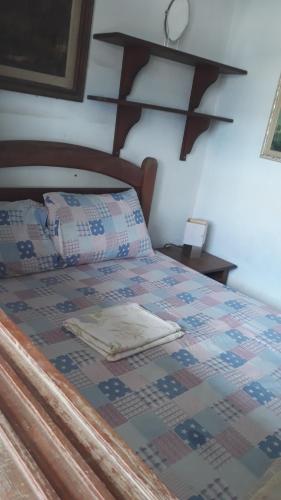 Una cama con edredón en un dormitorio en Casa de Veraneio, en Cabo Frío