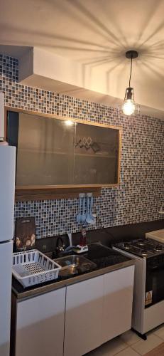 a kitchen with a sink and a stove top oven at Pedacinho de Lar in João Pessoa