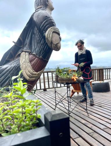 a man standing next to a table with a statue at Bledford Chiloé in Castro