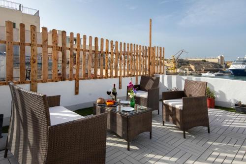 a patio with chairs and a table on a balcony at Traditional Maltese Townhouse - Close to Sea in Senglea