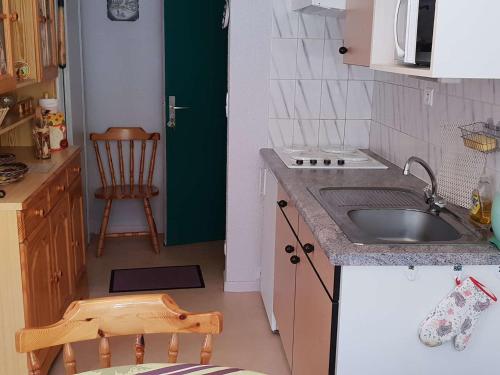 une petite cuisine avec un évier et une chaise dans l'établissement Appartement cosy T2bis pour 4-6 pers. à Cauterets, proche centre, parking gratuit, casier à skis, Est - FR-1-234-243, à Cauterets