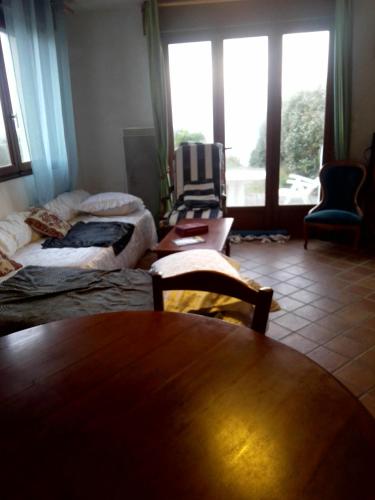 Zimmer mit 2 Betten, einem Tisch und einem Fenster in der Unterkunft Sundown in Audresselles