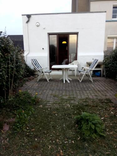 eine Terrasse mit 2 Stühlen und einem weißen Tisch in der Unterkunft Sundown in Audresselles