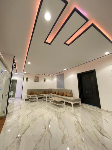 a lobby with a large marble floor with a couch at شاليهات غيوم الوسام للفلل الفندقية الفاخرة in Taif