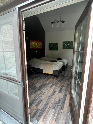 a bedroom with two beds and a sliding glass door at B&B AntiQua & Qook in Tongeren