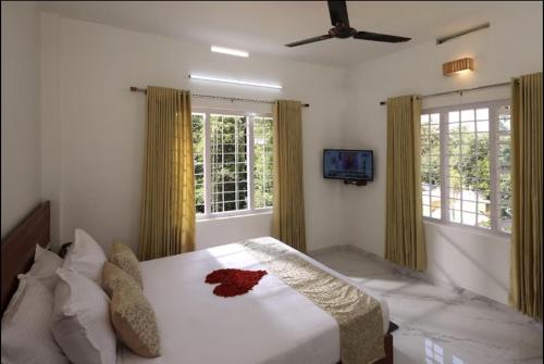 a bedroom with a bed and a tv and windows at Shiv Dwelling - Full Villa in Ujjain