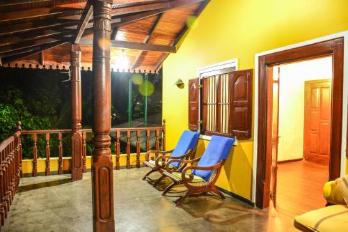 a porch with two chairs on a balcony at Araliya Gardens Hotel in Hikkaduwa