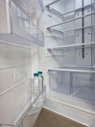 an empty refrigerator with two bottles of water in it at Yolo House in Daegu