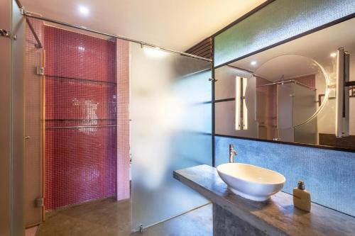 a bathroom with a sink and a mirror at StayVista at Toya Toya River View in Kozhikode