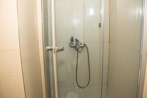 a shower stall with a glass door with a shower constructor at Occidental Wise Transit in Bucharest