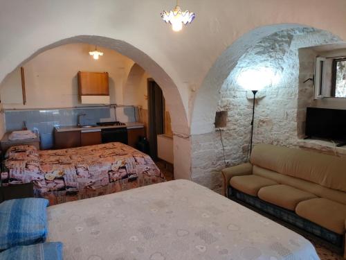 マルティナ・フランカにあるTrullo Franciscoのベッドルーム1室(ベッド1台、ソファ付)