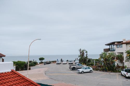 un estacionamiento con autos estacionados al lado del océano en 7 Pepper Street by African Perfection, en Jeffreys Bay