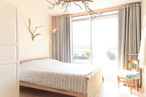 ein Schlafzimmer mit einem Bett und einem großen Fenster in der Unterkunft Bed met Paard in Bergen op Zoom