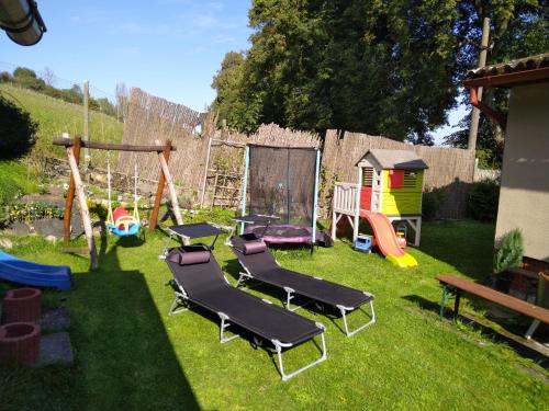 a backyard with a playground with chairs and a swing at Rekreační chata Menfis in Hořice na Šumavě