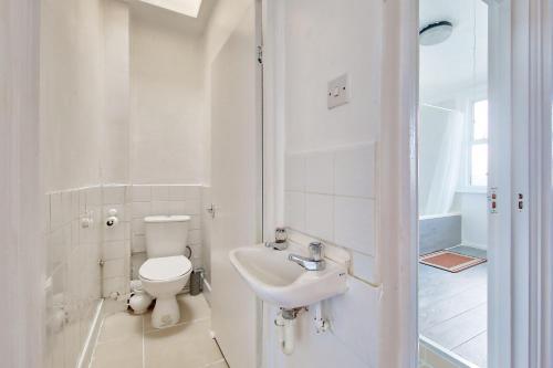 ein weißes Bad mit einem WC und einem Waschbecken in der Unterkunft Cozy London Flat in London
