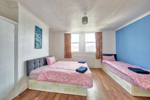 1 dormitorio con 2 camas y ventana en Cozy London Flat, en Londres