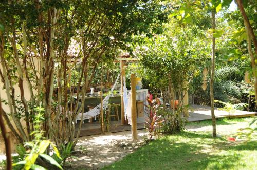 a garden with a swing in the middle of trees at Na Floresta Glamping in Pôrto de Pedras